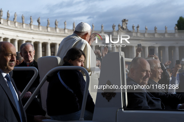 Pope Francis waves to the crowd from the popemobile as he arrives for the weekly general audience at St. Peter's Square in The Vatican on Oc...