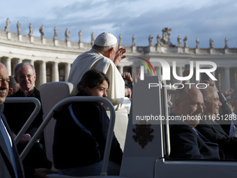 Pope Francis waves to the crowd from the popemobile as he arrives for the weekly general audience at St. Peter's Square in The Vatican on Oc...