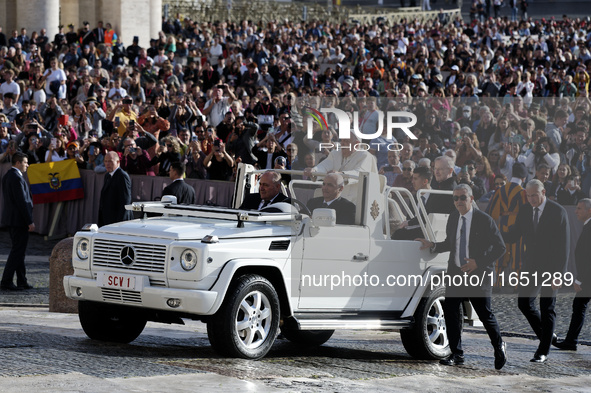 Pope Francis waves to the crowd from the popemobile as he arrives for the weekly general audience at St. Peter's Square in The Vatican on Oc...