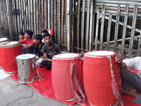 Traditional drummers play their instruments at the Siliguri Town railway station as they wait to be hired to perform for the Hindu festival...