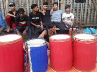 Traditional drummers play their instruments at the Siliguri Town railway station as they wait to be hired to perform for the Hindu festival...