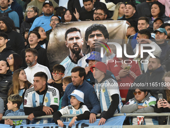 Argentina's fans hold a Lionel Messi and Diego Maradona flag before a World Cup Qualifiers match between Argentina and Paraguay at Estadio M...