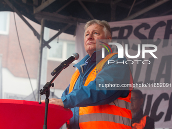 Martin Burkert, chairman of the EVG union, speaks on the stage as members from the EVG railway workers rally against the federal transportat...