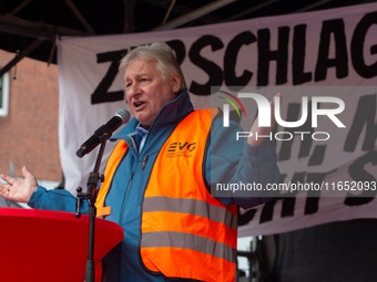 Martin Burkert, chairman of the EVG union, speaks on the stage as members from the EVG railway workers rally against the federal transportat...