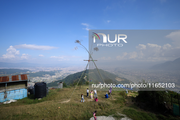 Nepali people play on a swing installed on a hillside surrounding Kathmandu Valley with the arrival of the fortnightly festival of Dashain,...