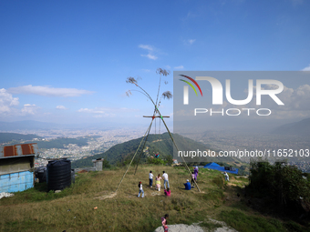 Nepali people play on a swing installed on a hillside surrounding Kathmandu Valley with the arrival of the fortnightly festival of Dashain,...