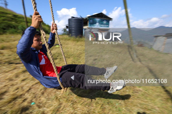 A Nepali boy plays on a swing installed on a hillside surrounding Kathmandu Valley with the arrival of the fortnightly festival of Dashain,...