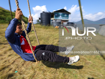 A Nepali boy plays on a swing installed on a hillside surrounding Kathmandu Valley with the arrival of the fortnightly festival of Dashain,...