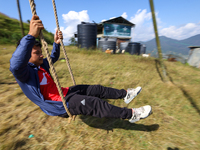 A Nepali boy plays on a swing installed on a hillside surrounding Kathmandu Valley with the arrival of the fortnightly festival of Dashain,...