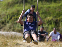 A Nepali boy gestures as he plays on a swing installed on a hillside surrounding Kathmandu Valley with the arrival of the fortnightly festiv...