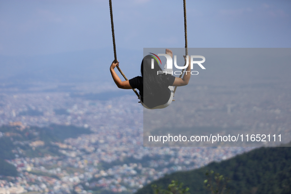 A Nepali woman plays on a swing installed on a hillside surrounding Kathmandu Valley with the arrival of the fortnightly festival of Dashain...