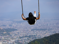 A Nepali woman plays on a swing installed on a hillside surrounding Kathmandu Valley with the arrival of the fortnightly festival of Dashain...