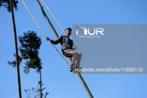 A Nepali man plays on a swing installed on a hillside surrounding Kathmandu Valley with the arrival of the fortnightly festival of Dashain,...