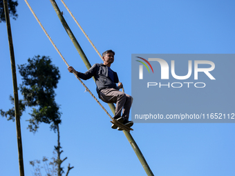 A Nepali man plays on a swing installed on a hillside surrounding Kathmandu Valley with the arrival of the fortnightly festival of Dashain,...