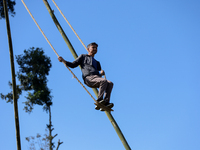 A Nepali man plays on a swing installed on a hillside surrounding Kathmandu Valley with the arrival of the fortnightly festival of Dashain,...