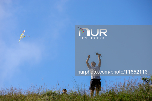 A Nepali man flies a kite from a hilltop surrounding Kathmandu Valley with the arrival of the fortnightly festival of Dashain, on October 9,...