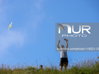 A Nepali man flies a kite from a hilltop surrounding Kathmandu Valley with the arrival of the fortnightly festival of Dashain, on October 9,...