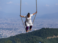 A Nepali woman plays on a swing installed on a hillside surrounding Kathmandu Valley with the arrival of the fortnightly festival of Dashain...