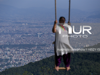 A Nepali woman plays on a swing installed on a hillside surrounding Kathmandu Valley with the arrival of the fortnightly festival of Dashain...