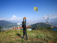 A Nepali boy flies a kite from a hilltop surrounding Kathmandu Valley with the arrival of the fortnightly festival of Dashain, on October 9,...