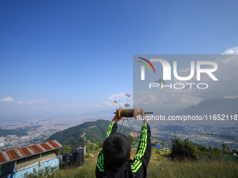 A Nepali boy flies a kite from a hilltop surrounding Kathmandu Valley with the arrival of the fortnightly festival of Dashain, on October 9,...