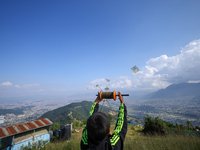 A Nepali boy flies a kite from a hilltop surrounding Kathmandu Valley with the arrival of the fortnightly festival of Dashain, on October 9,...