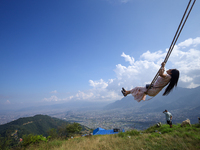 A Nepali woman plays on a swing installed on a hillside surrounding Kathmandu Valley with the arrival of the fortnightly festival of Dashain...