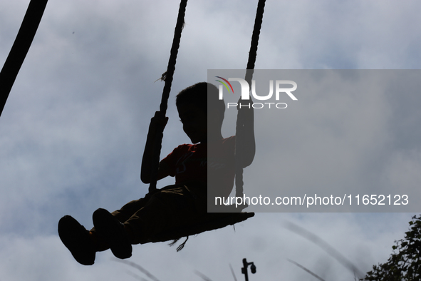 A Nepali boy plays on a swing installed on a hillside surrounding Kathmandu Valley with the arrival of the fortnightly festival of Dashain,...