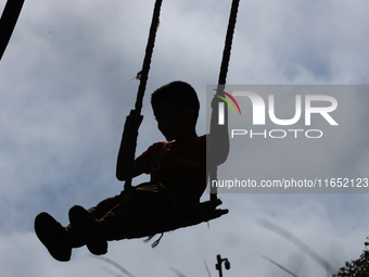 A Nepali boy plays on a swing installed on a hillside surrounding Kathmandu Valley with the arrival of the fortnightly festival of Dashain,...