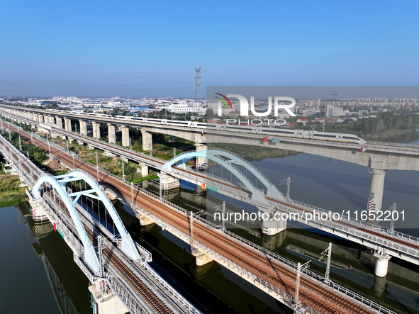 A bullet train runs on a railway bridge in Lianyungang, China, on October 9, 2024. 