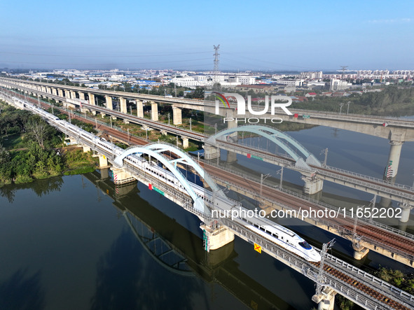 A bullet train runs on a railway bridge in Lianyungang, China, on October 9, 2024. 