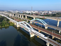 A bullet train runs on a railway bridge in Lianyungang, China, on October 9, 2024. (