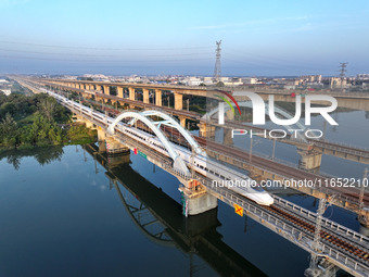 A bullet train runs on a railway bridge in Lianyungang, China, on October 9, 2024. (