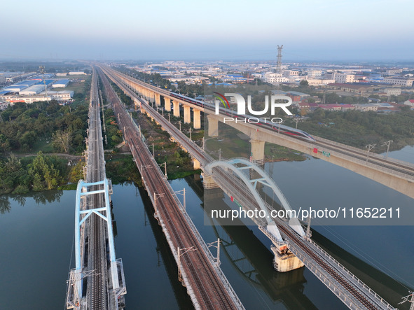 A bullet train runs on a railway bridge in Lianyungang, China, on October 9, 2024. 