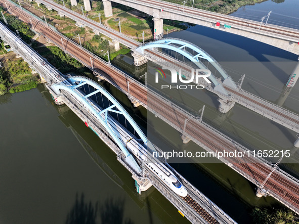 A bullet train runs on a railway bridge in Lianyungang, China, on October 9, 2024. 