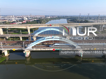 A bullet train runs on a railway bridge in Lianyungang, China, on October 9, 2024. (