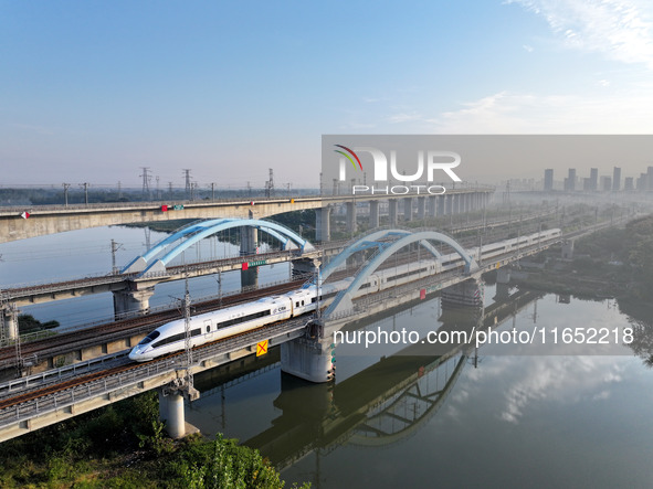 A bullet train runs on a railway bridge in Lianyungang, China, on October 9, 2024. 