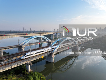 A bullet train runs on a railway bridge in Lianyungang, China, on October 9, 2024. (