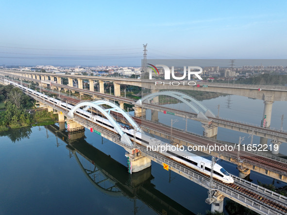 A bullet train runs on a railway bridge in Lianyungang, China, on October 9, 2024. 