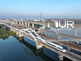 A bullet train runs on a railway bridge in Lianyungang, China, on October 9, 2024. (