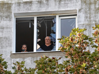 People look out of a broken window of the residential building damaged by a Russian drone attack in Chornomorsk, Odesa region, southern Ukra...