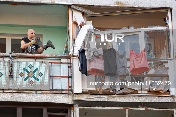 A man stands on the balcony of a residential building damaged by a Russian drone attack in Chornomorsk, Odesa region, southern Ukraine, on O...