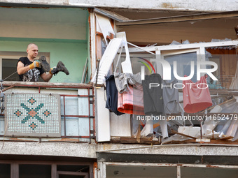 A man stands on the balcony of a residential building damaged by a Russian drone attack in Chornomorsk, Odesa region, southern Ukraine, on O...