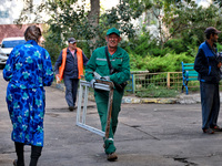 City crew work outside a residential building damaged by a Russian drone attack in Chornomorsk, Odesa region, southern Ukraine, on October 9...