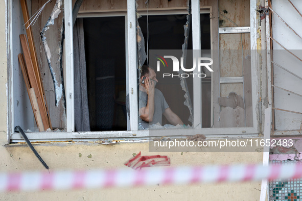 A man stands on the balcony of a residential building damaged by a Russian drone attack in Chornomorsk, Odesa region, southern Ukraine, on O...