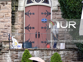 A person works on the steps of St. Paul's United Church as pedestrians walk along Main Street in downtown Brampton, Ontario, Canada, on Octo...