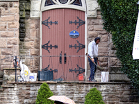 A person works on the steps of St. Paul's United Church as pedestrians walk along Main Street in downtown Brampton, Ontario, Canada, on Octo...