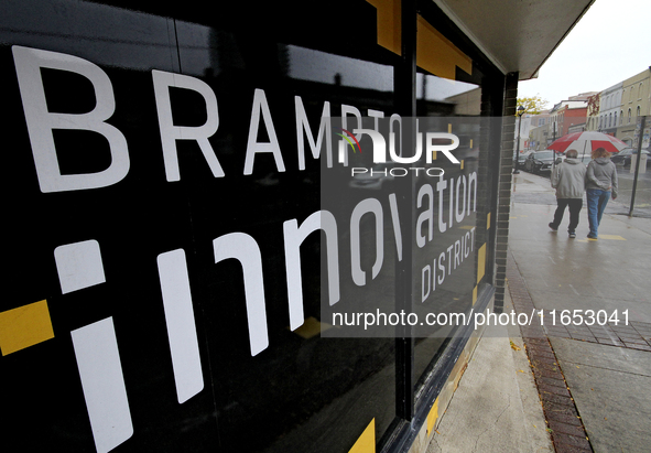 Pedestrians walk along Main Street in downtown Brampton, Ontario, Canada, on October 9, 2024, after a light rain. 