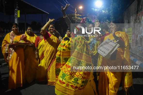 Devotees dance with a banana tree trunk during a ritual Nabapatrika as part of the Durga Puja festival in the early morning in Kolkata, Indi...