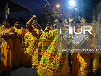 Devotees dance with a banana tree trunk during a ritual Nabapatrika as part of the Durga Puja festival in the early morning in Kolkata, Indi...